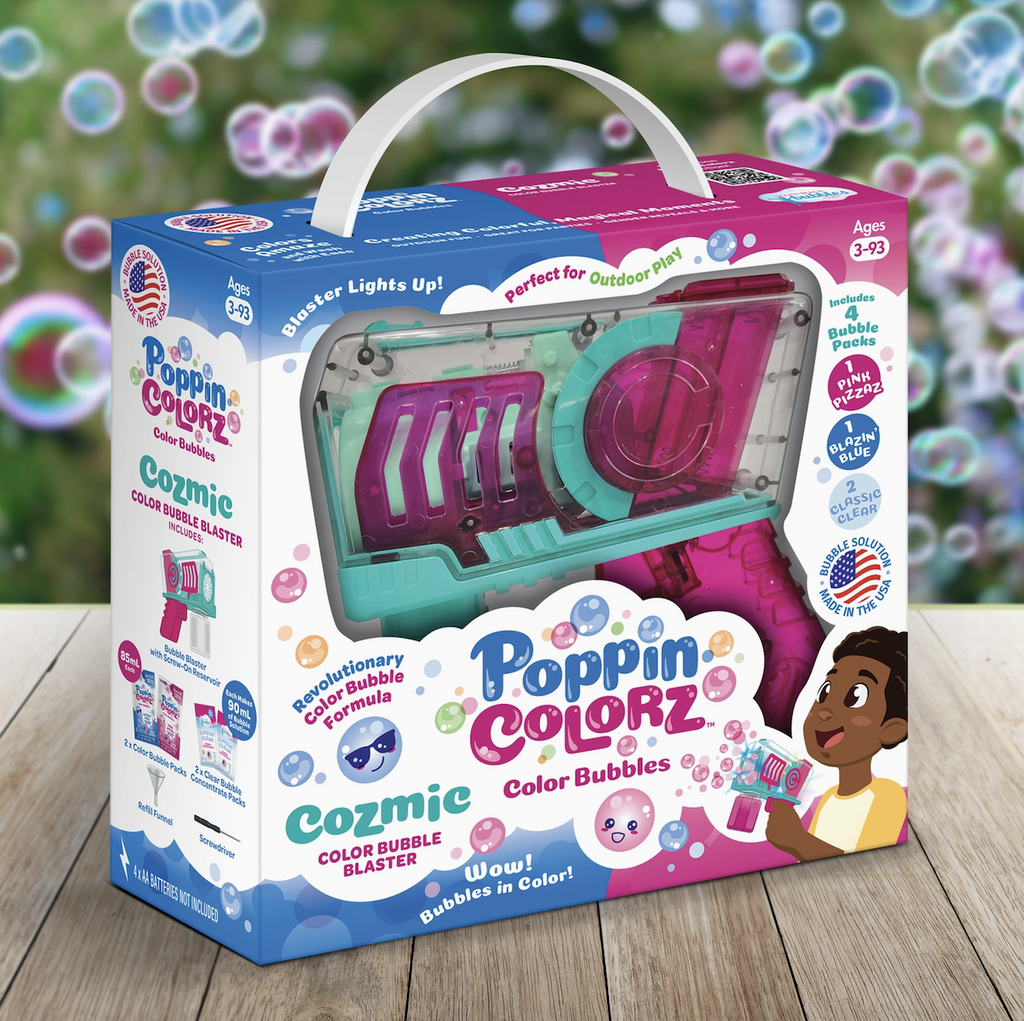The Poppincolorz Cozmic Color Bubble Blaster packaged in a colorful blue and pink box with a clear window that shows the transparent blaster with teal and pink highlights. 