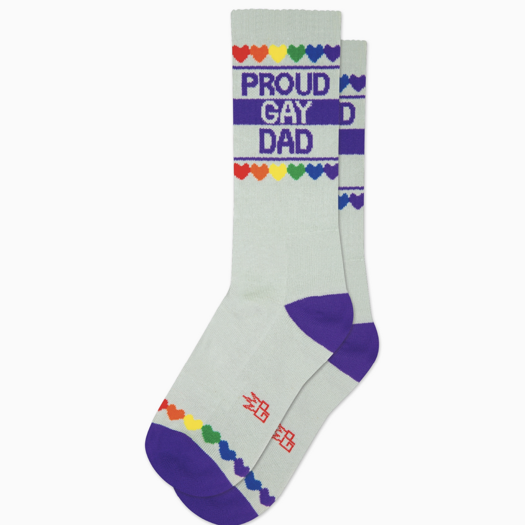 White tube socks with royal blue stripes and rainbow colored hearts that read "Proud Gay Dad" 