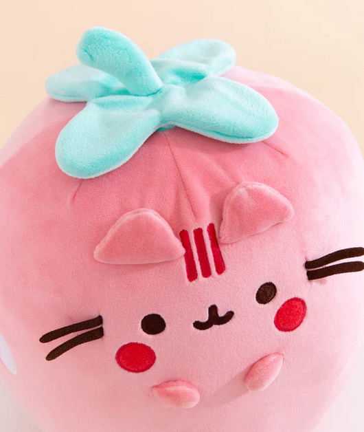 Close up view of the top of the Strawberry Pusheen plush, her sweet face is smiling with bright pink cheeks. 