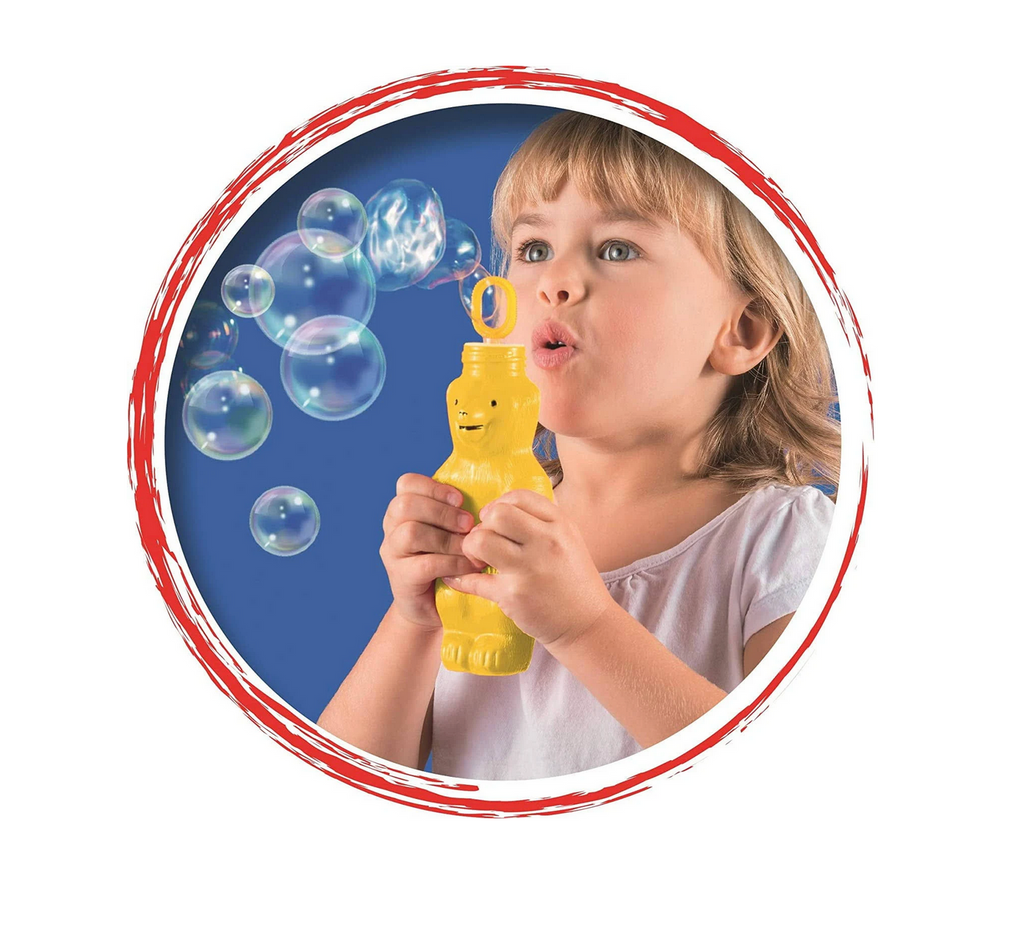 A young girl holding a yellow bubble bear and blowing bubbles. 