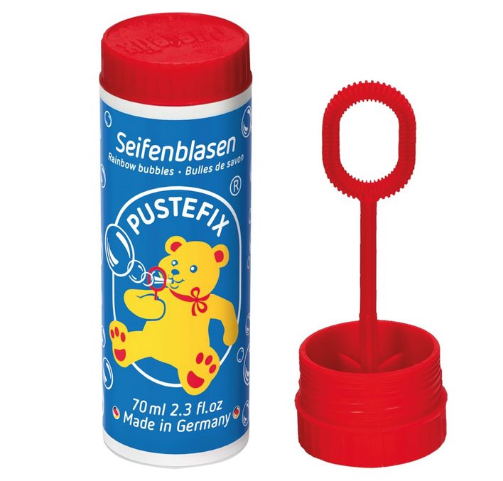 Pustefix bubble tube with blue label and red top. The bubble wand is attached to the inside of the top. 