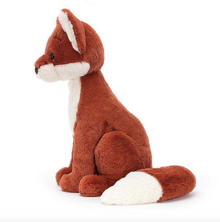Left side view of Quinn Fox plush sitting up and showing off his white chest and red fur. 