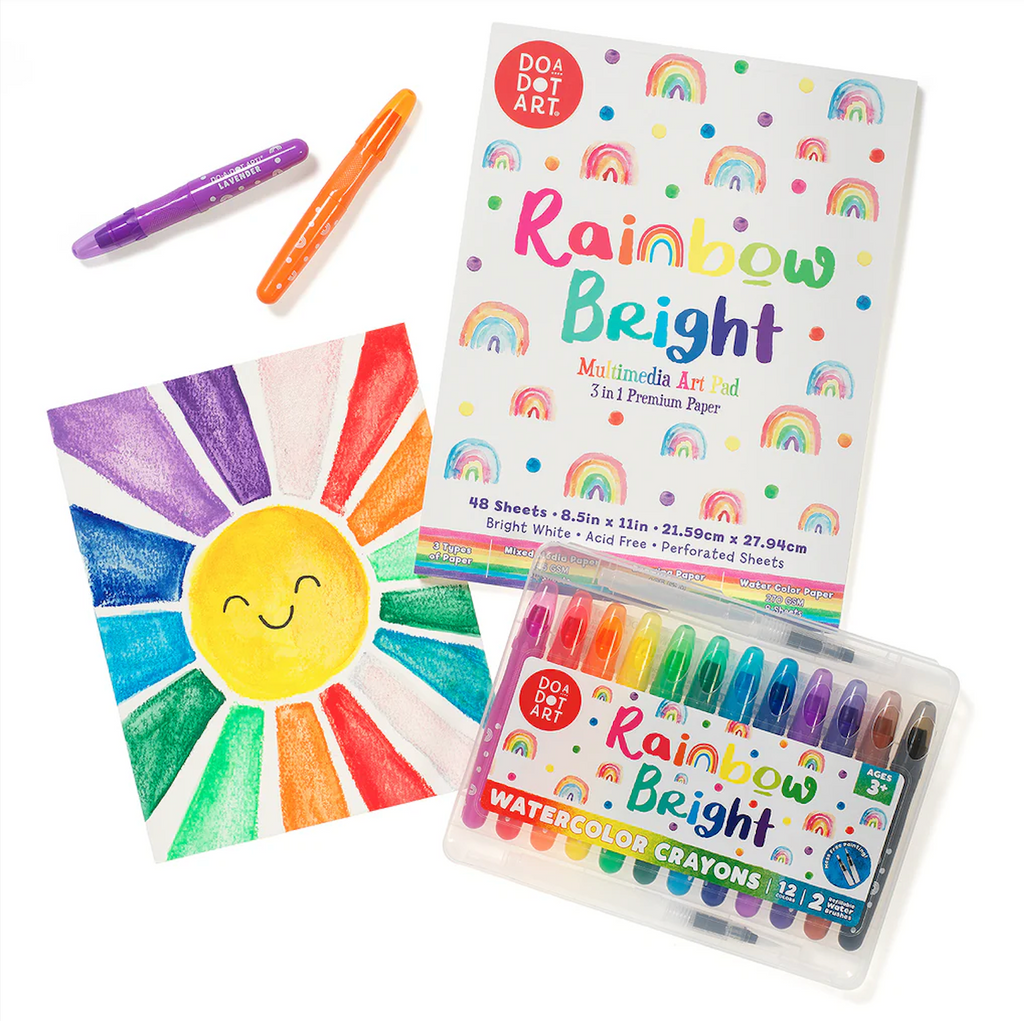 The Rainbow Bright Mixed Media Art Pad.  A page has been torn out and a drawing of a colorful sun with rainbow colored rays and a set of watercolor crayons is also pictured. 