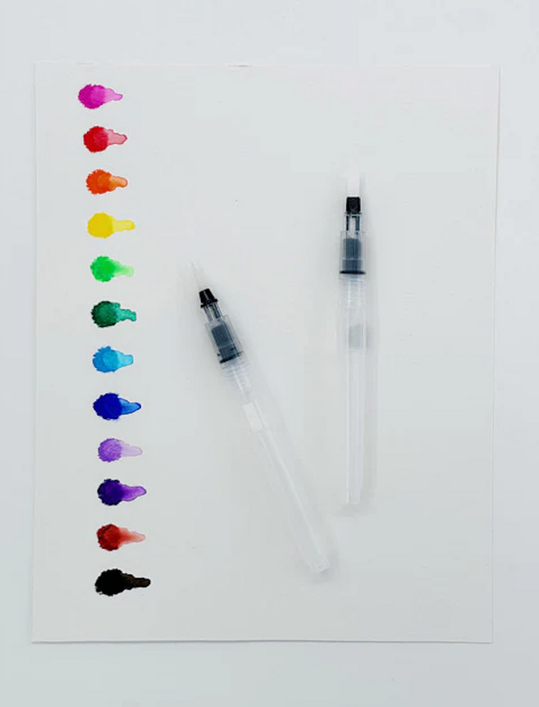 A sheet of white paper with colored dots made from each of the 12 crayons in the Rainbow Bright Watercolor Crayon set The two refillable water brushes have been used to blend each color out. 