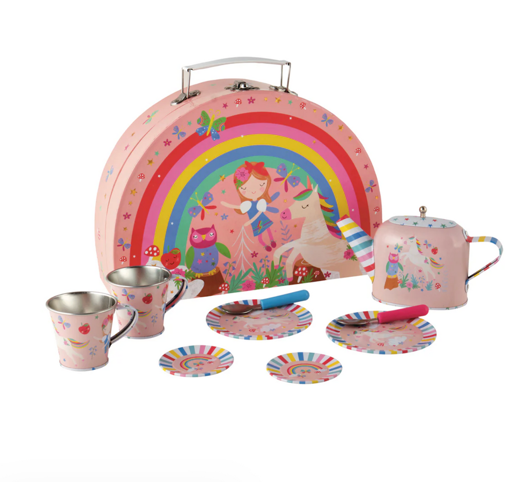Children's tea set with colorful tin, cups, saucers, and teapot situated in front of the pink carrying case with woodland animals and a fairy under a rainbow pictured on the front. 
