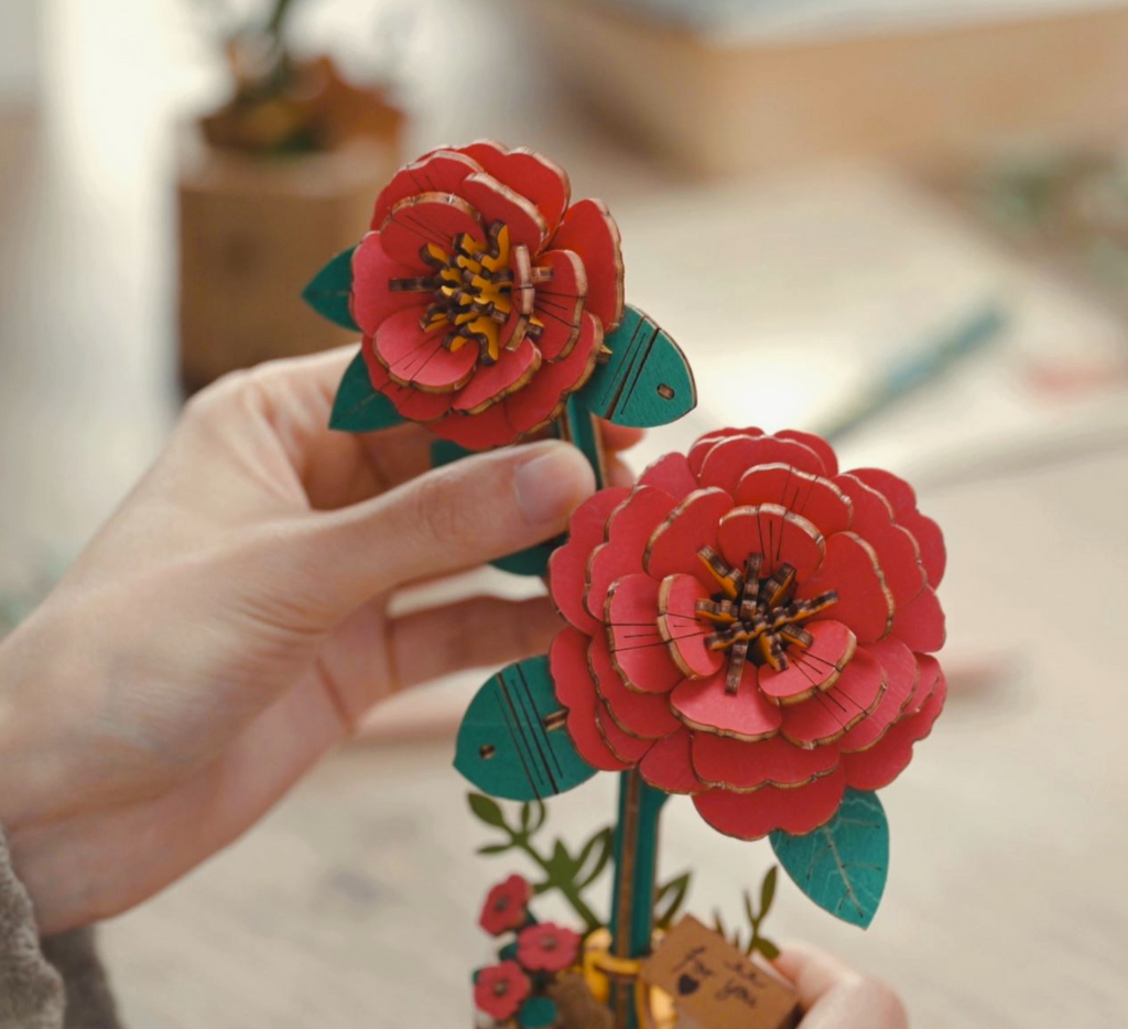 Hands building the 3D wooden flower puzzle.