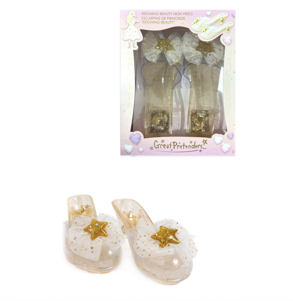 Reigning Beauty High Heel dress up shoes in gold. There is a pair in the foreground with their sparkly stars and tulle bows and a pair boxed in a packaged with clear plastic on the front so that all the gold glittery details can be seen. 