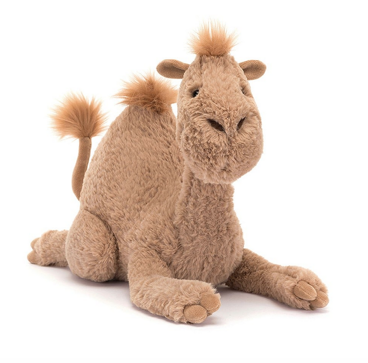 Richie Dromedary plush laying down and facing forward. His cute face is ready for a hug. 
