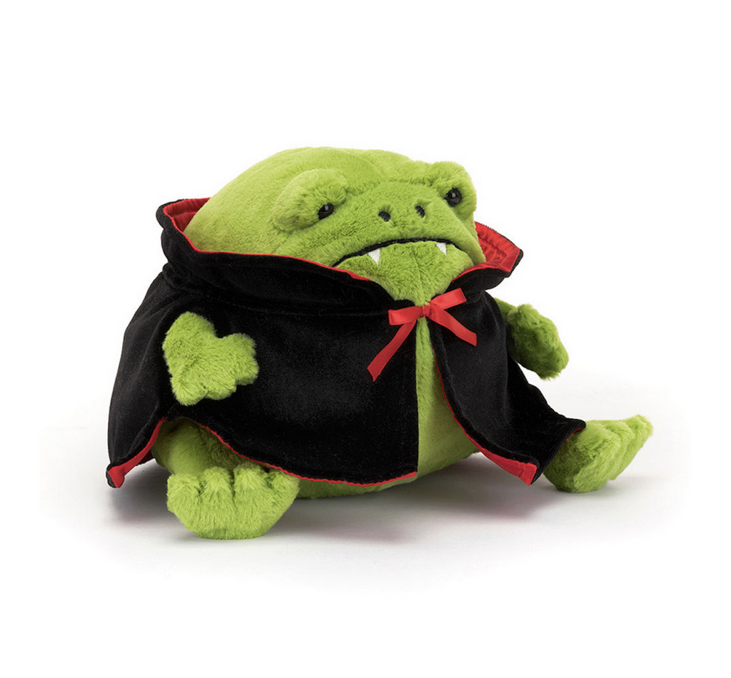 Plush green frog stuffed animal wearing a black cape with fangs. 