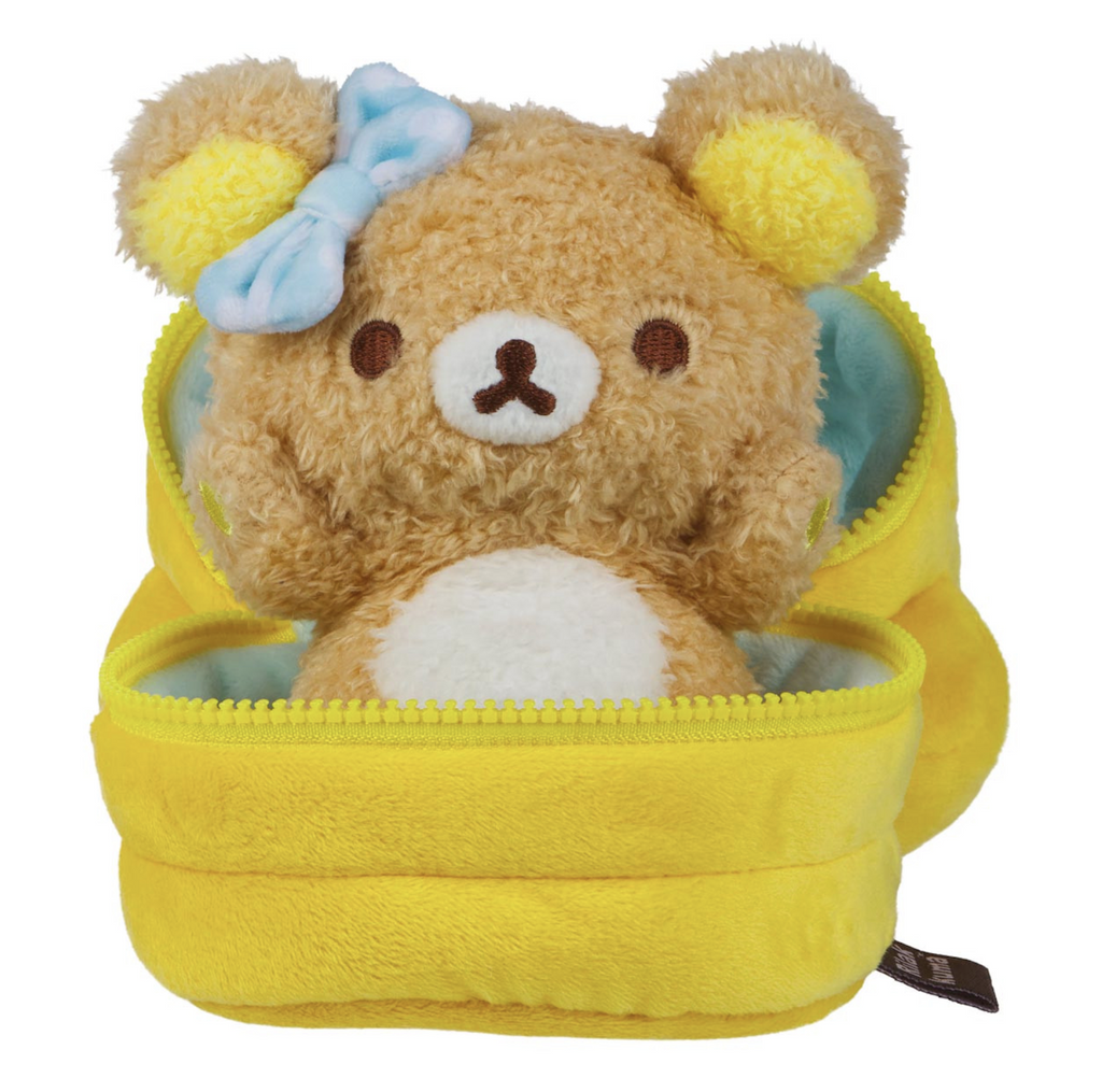 Plush Rilakkuma with a blue bow by their right ear, sitting in a plush stack of pancakes. 