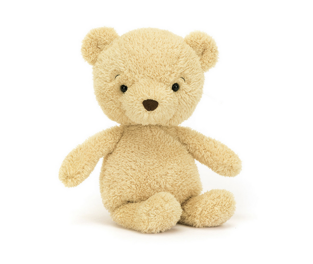 Honey colored plush bear sitting up with his arms stretched out.