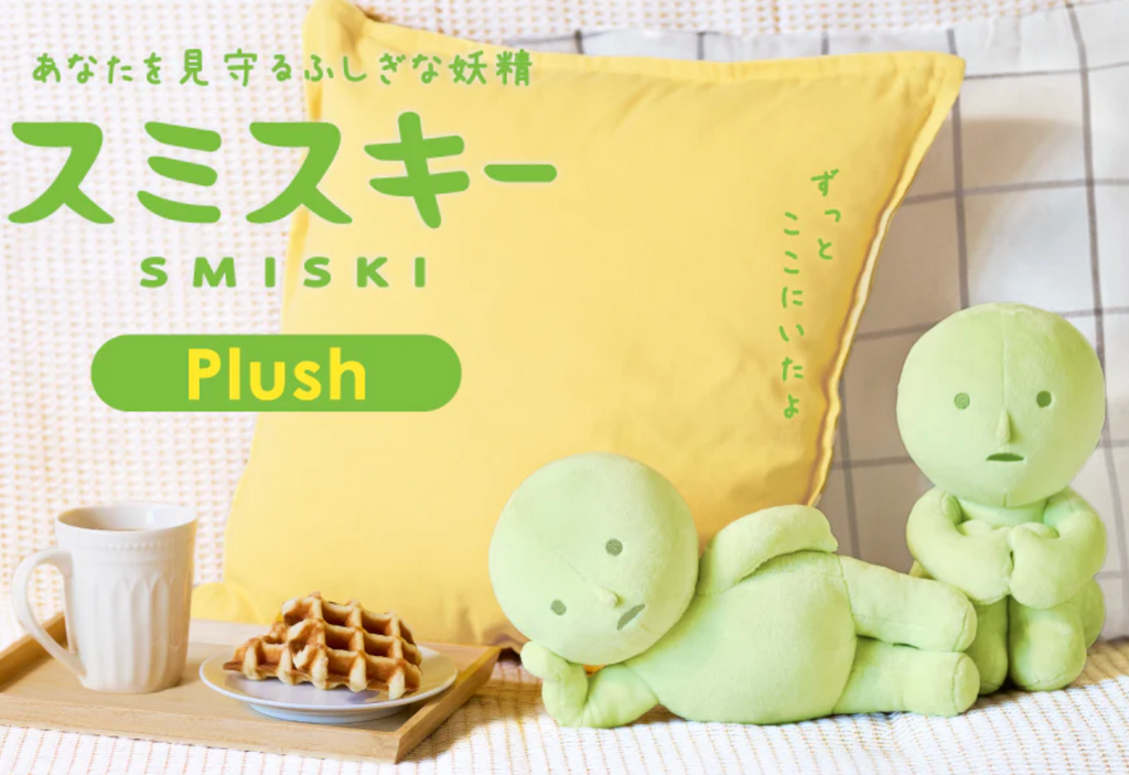 Smiski plush Lounging and Hugging Knees placed beside a breakfast tray on a bed. 