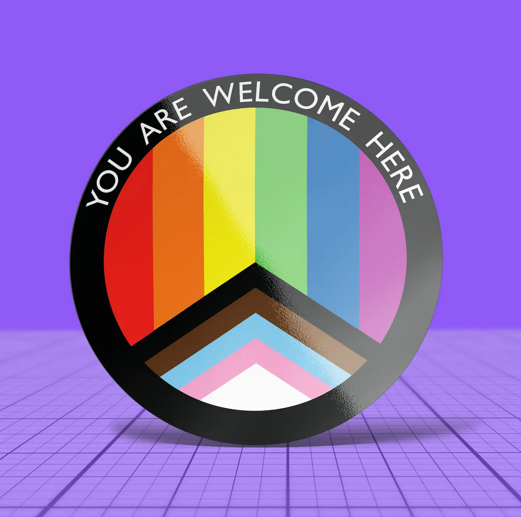 Round, progress flag window cling reads 'YOU ARE WELCOME HERE' 