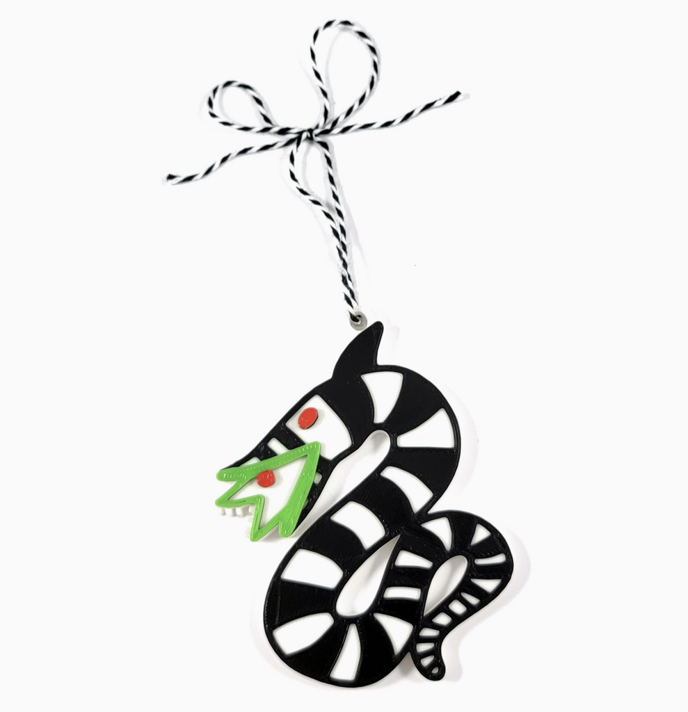 Black and white sandworm ornament with green outline around the inside mouth of the sandworm. 