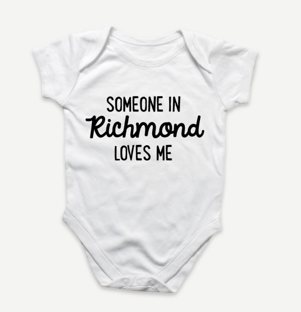 White baby onesie that reads "Someone in Richmond loves me" in black text.