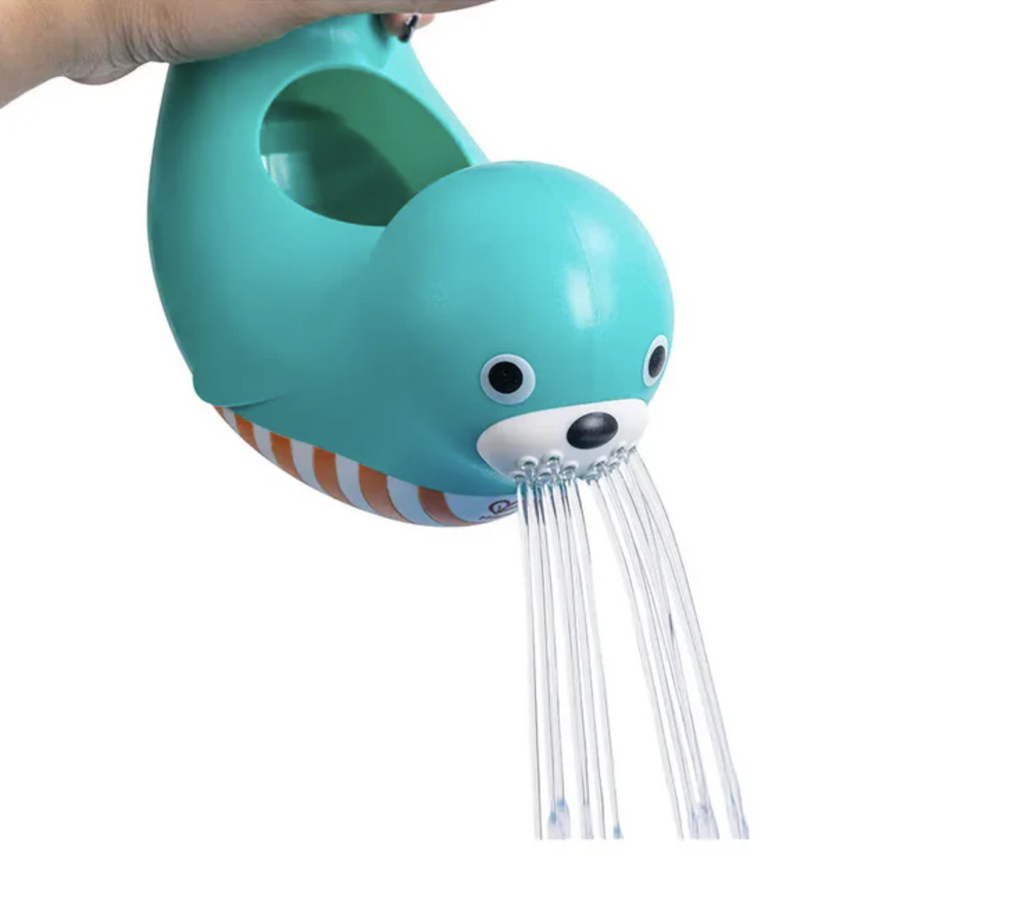 Hand pouring water out of blue seal shaped jug.