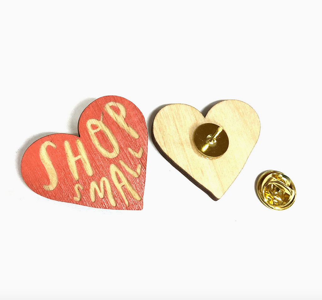 Front and back of the red heart shaped pin that reads "Shop Small"