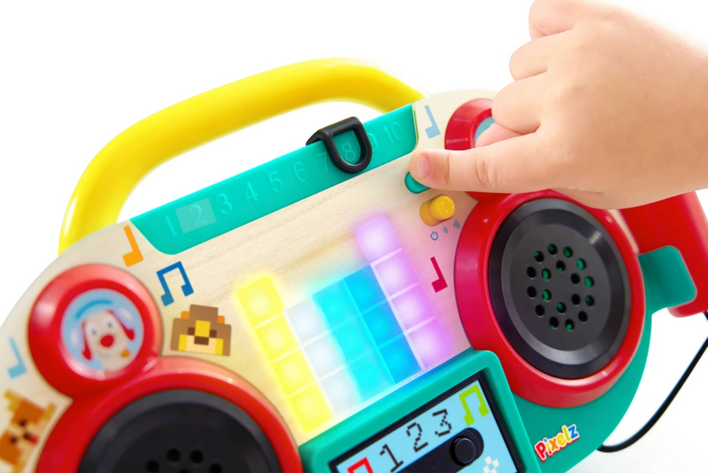 A close up picture of the Sing Along Pixel Boombox showing a childs hand pressing buttons, and the boombox lighting up 