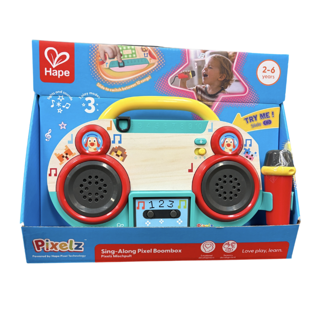 The Sing Along Pixel Boombox packaged in an open box with a try me feature and pictures of children playing with the toy covering the box. 