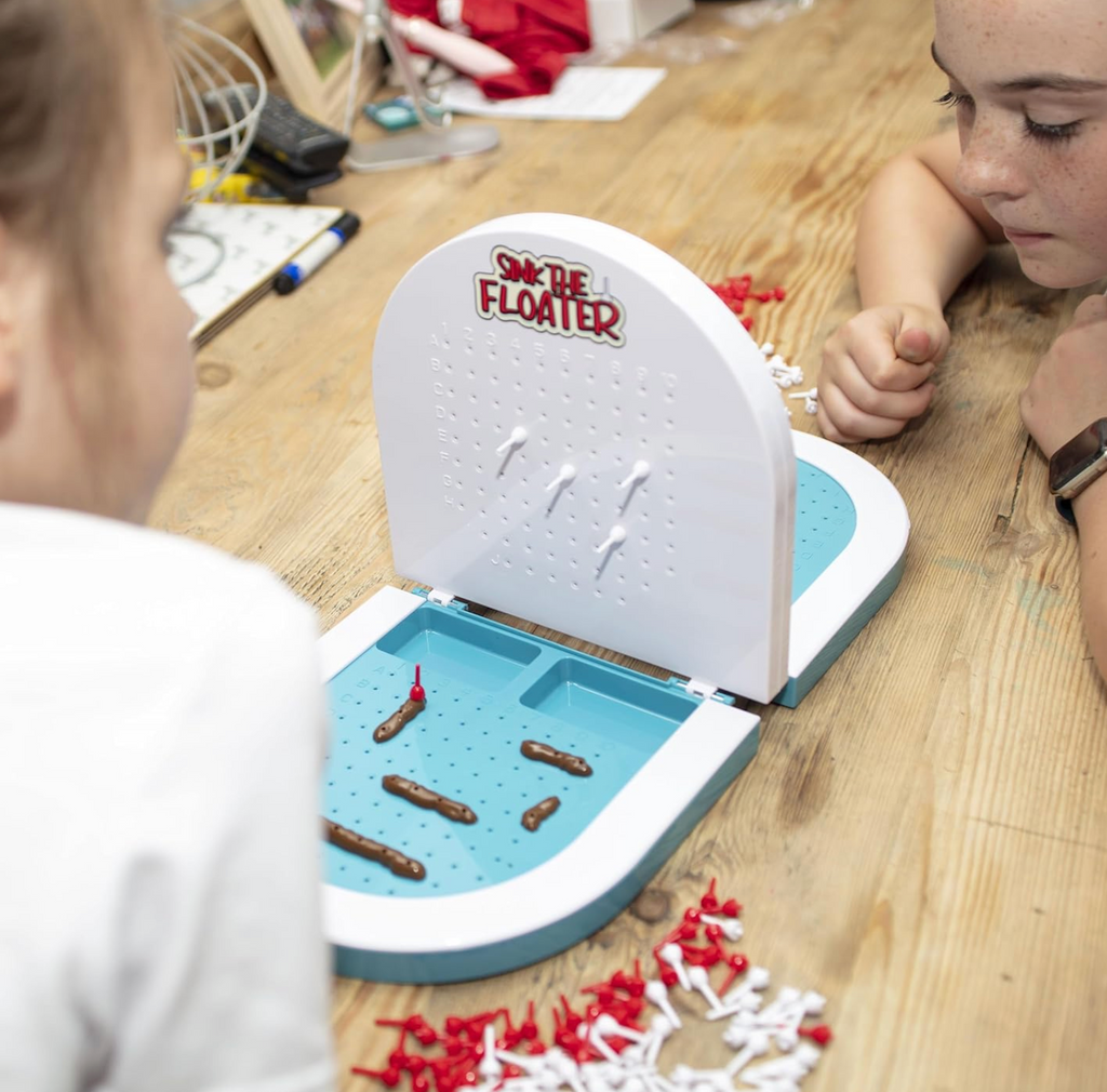 Children playing Sink the Floater on the toilet shaped game board. 