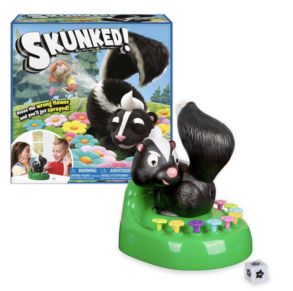 Skunked! game box in the background with the Skunk game piece and die in the foreground. 