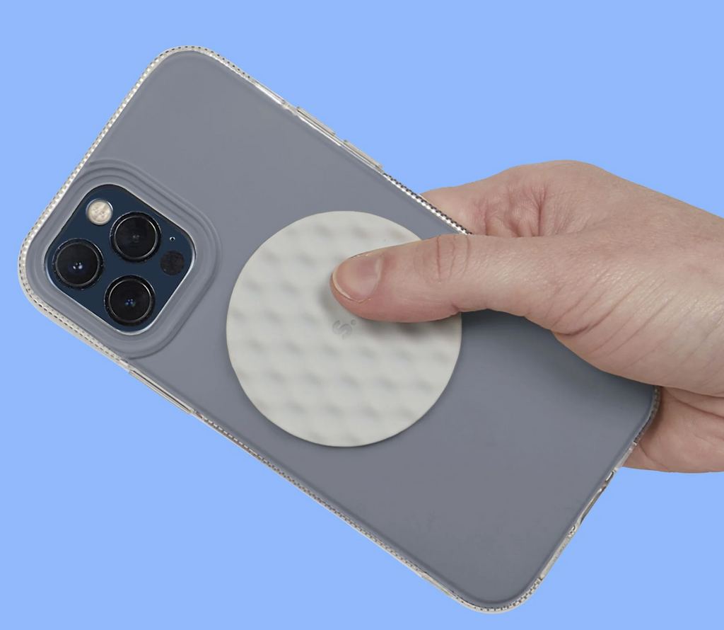 The Slabs Sensory Sticker Mesh Round in gray attached to the back of a smart phone. 