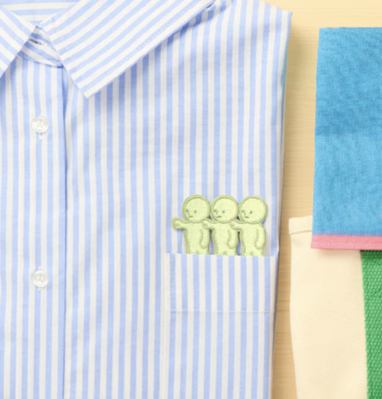 Smiski 3 little embroidered sticker on a striped shirt.