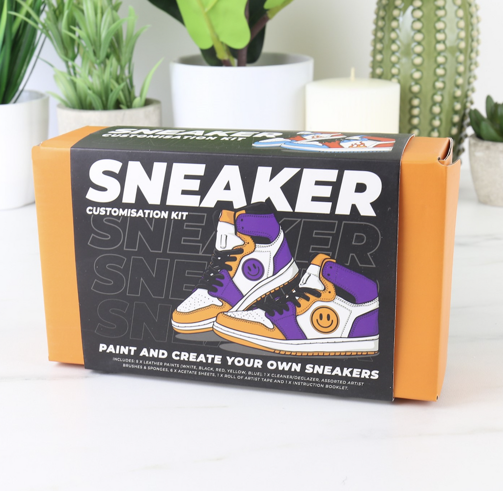 The Sneaker Customization Kit with a bright orange box and sleeve with an illustrated pair of customized sneakers. 