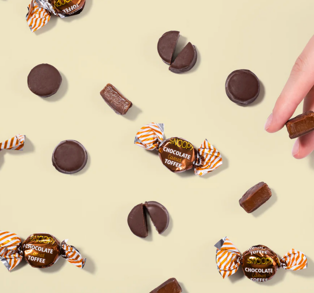 Snoopy chocolate toffee candy pictured both in the wrapper and also unwrapped. 