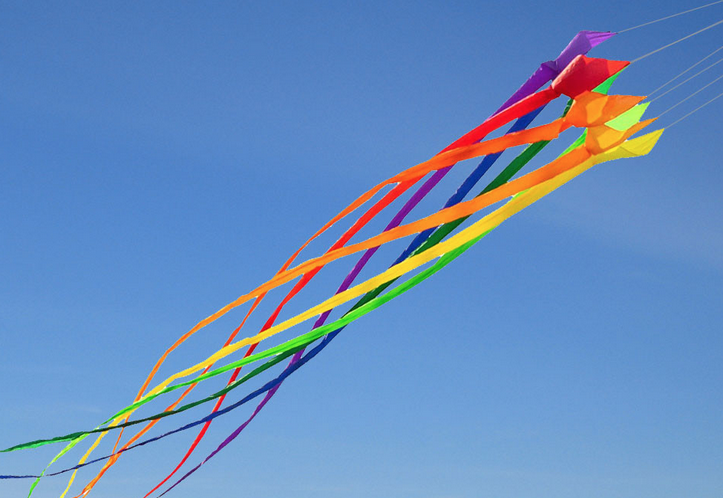 Rainbow Swirl Line Laundry for kites with colorful ribbons flying in the sky.