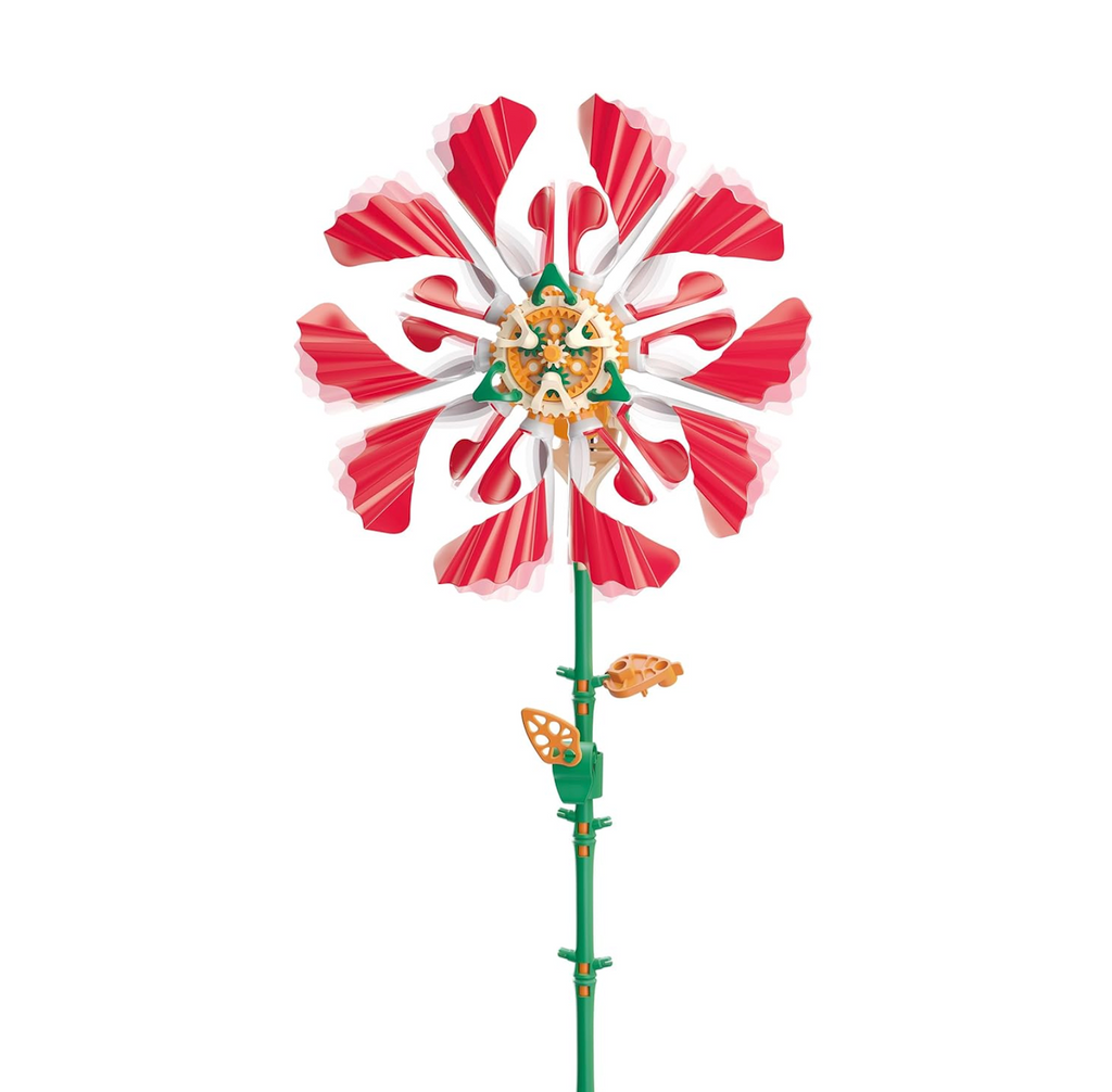 Red and white flower that is a kinetic sculpture with green stem and solar panel that makes it move. 