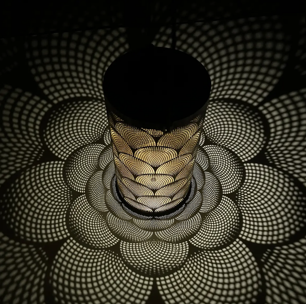 Solar Lantern with geometric pattern illuminated and projecting the intricate light patterns on the floor and walls. 