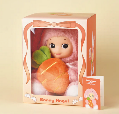 The Sonny Angel Cuddly Rabbit in Pink in it's box with a clear plastic window showing Sonny Angel hugging the stuffed carrot. 
