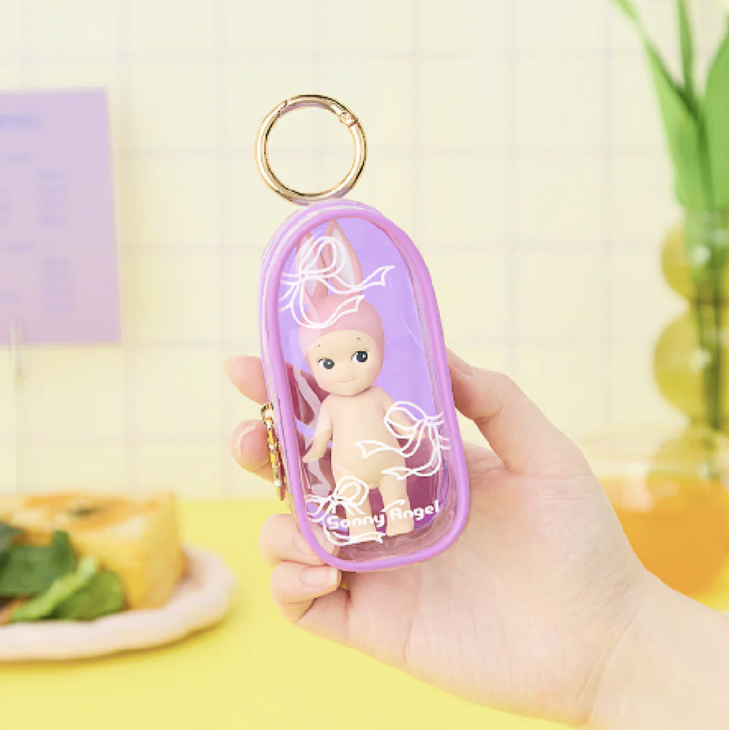 Hand holding a pink Sonny Angel Bestie case containing a Sonny Angel figure.
