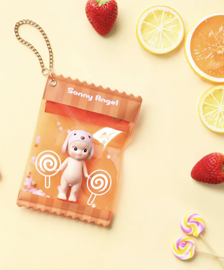 Sonny Angel Sweet Candy Bestie Case in orange, with a Sonny Angel figure tucked safely inside. The pouch has a gold chain that allows you to attach it to your bag, or anywhere to bring you favorite Sonny Angel with you. 