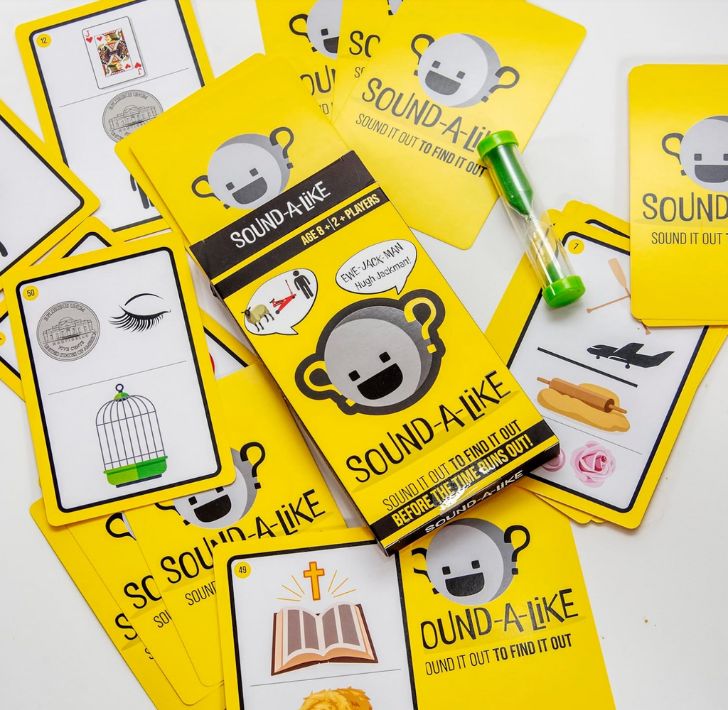 Sound A Like card game with yellow packaging and game cards scattered all around. 