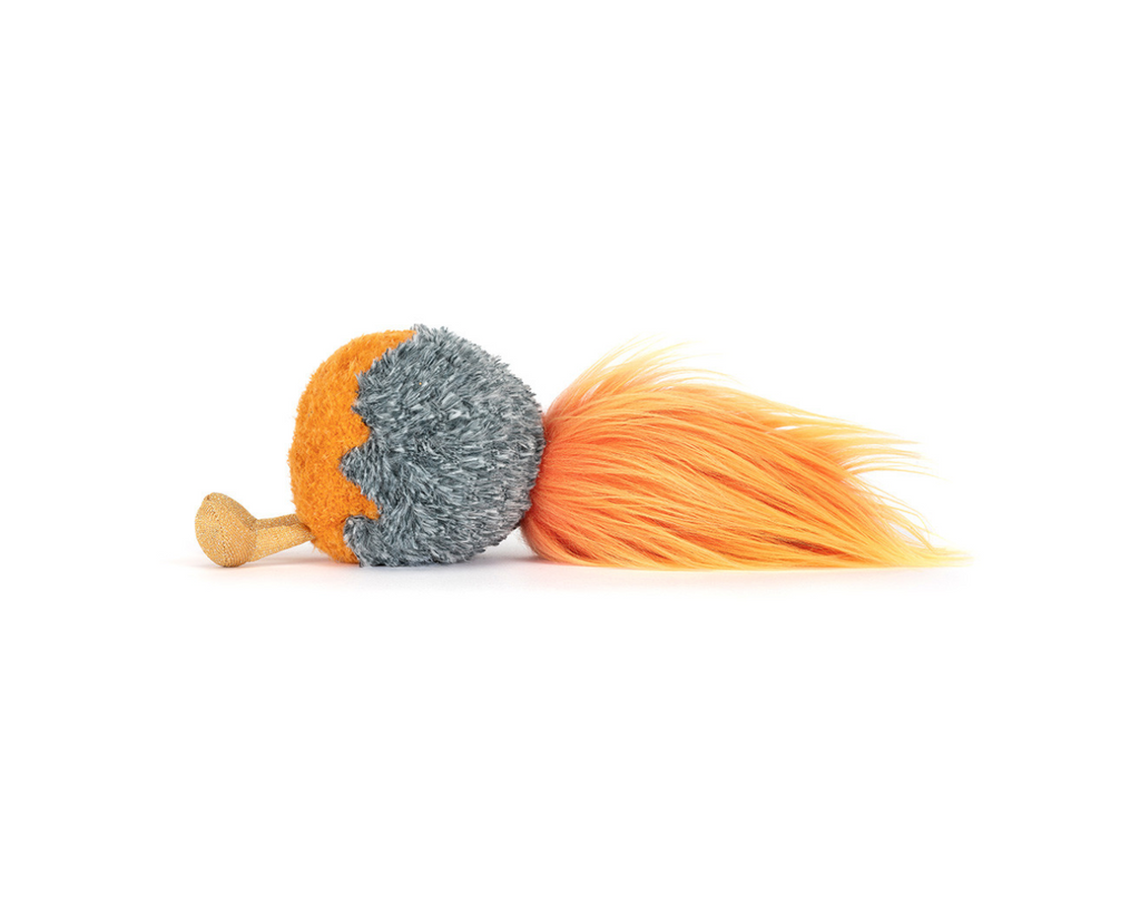 Side view of a small plush space comet on a white background.