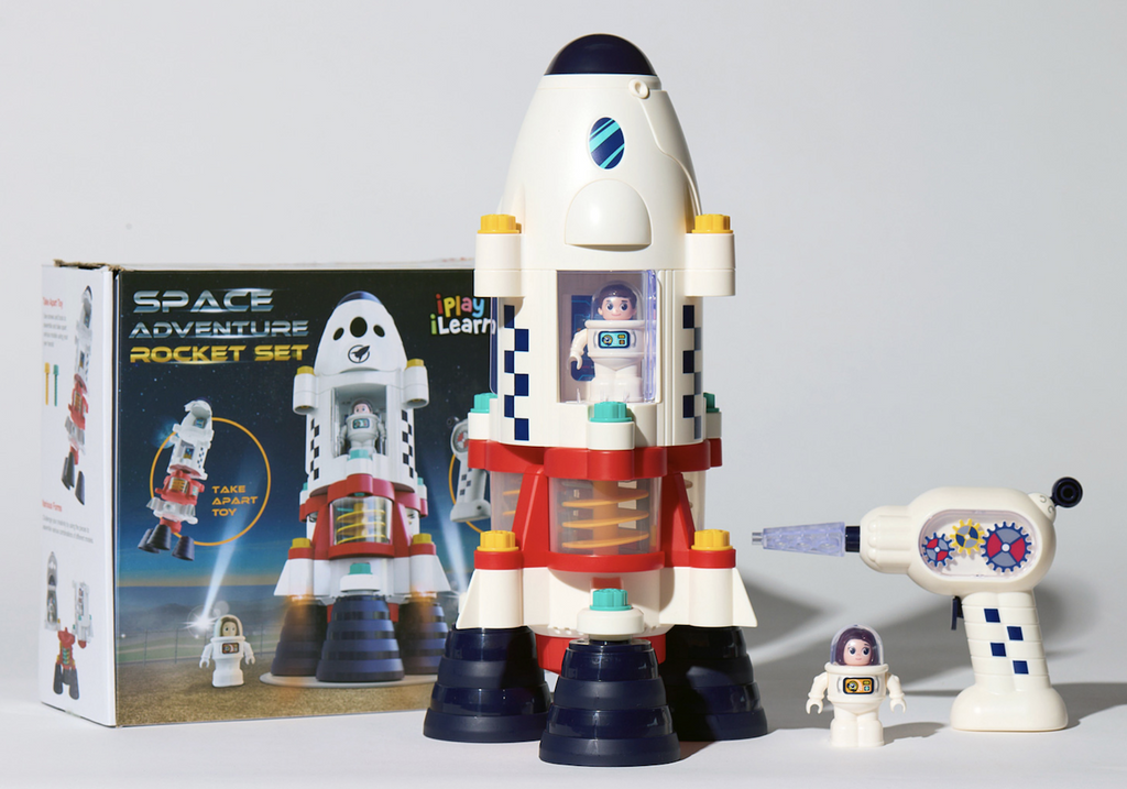 Space Adventure Rocket Set in front of the box with one astronaut figure in the rocket and one standing beside it along with the drill. 