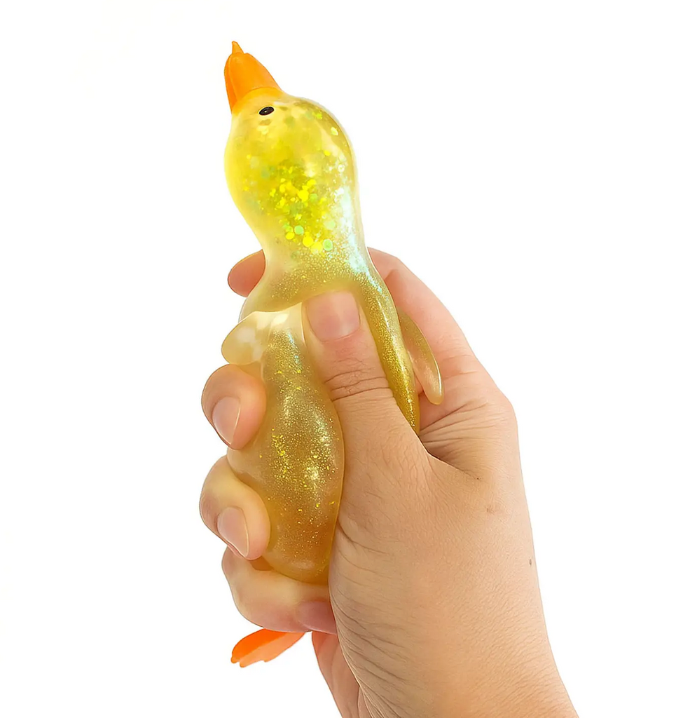 A hand squeezing a Sparkly Squishy Duck a squishy sensory toy shaped like a duck, filled with glitter. 