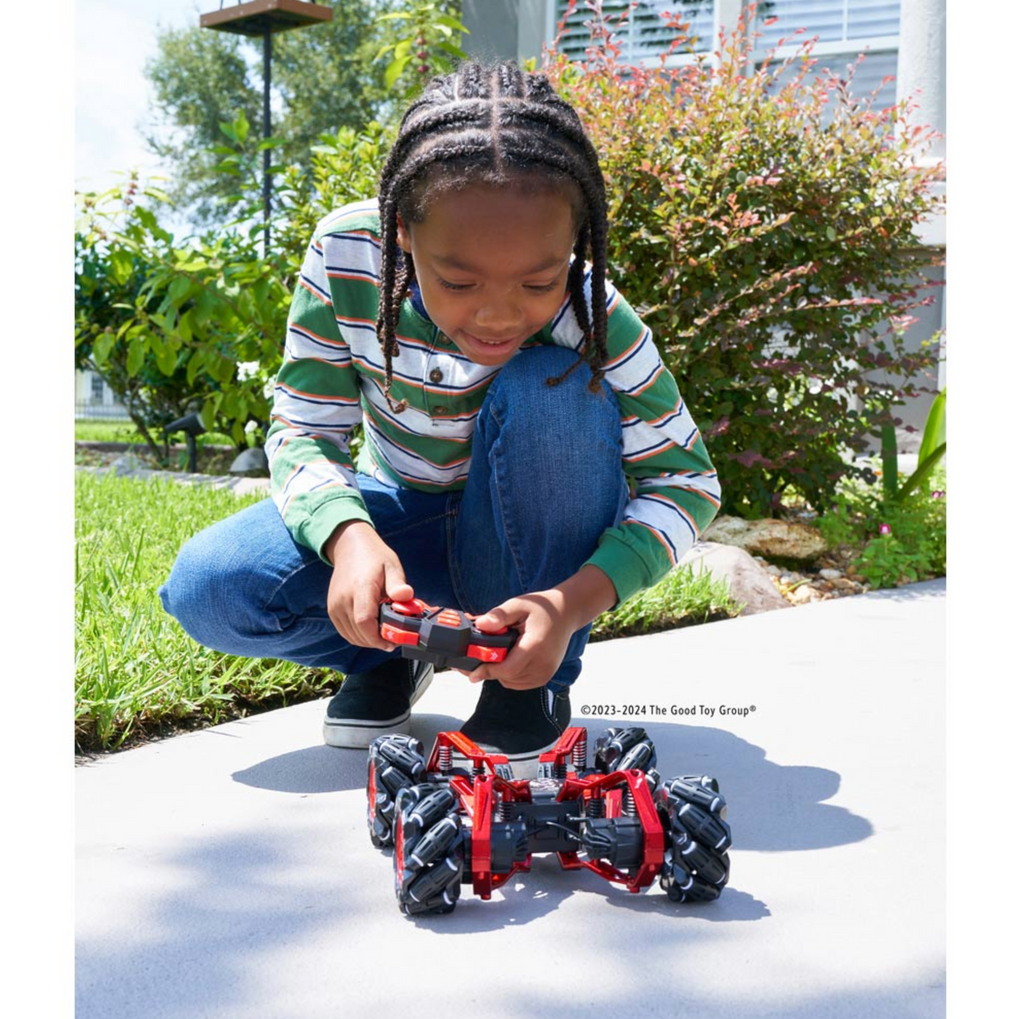 Young boy playing with the Spider RC Stunt Car outside,holding remote control.