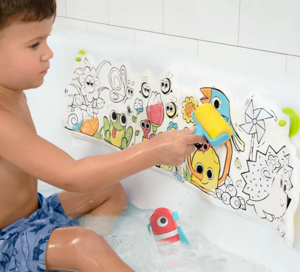 A young child in the tub using the sponge roller to reveal bright colors on the Spray N Roll Magic Book. 
