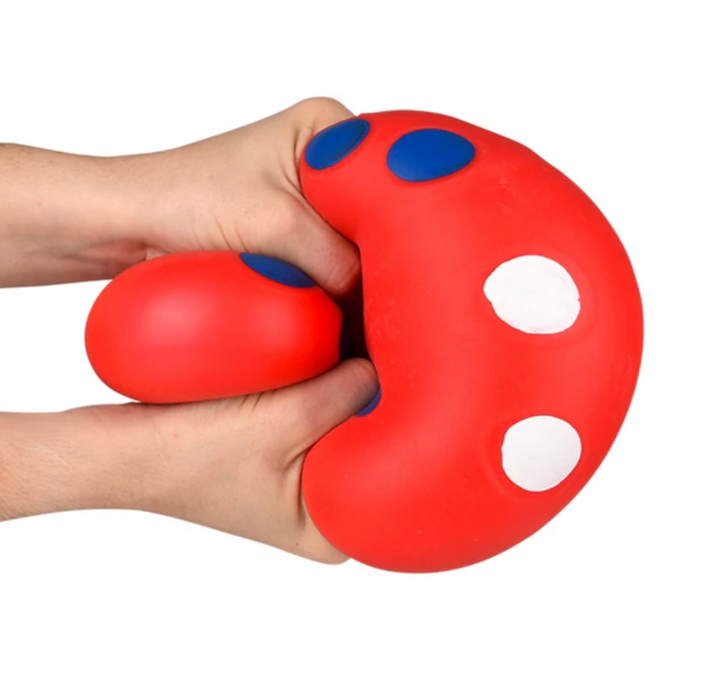 Two hands holding and squeezing the Squish and Roll Mega Marshmalllow Dice. 