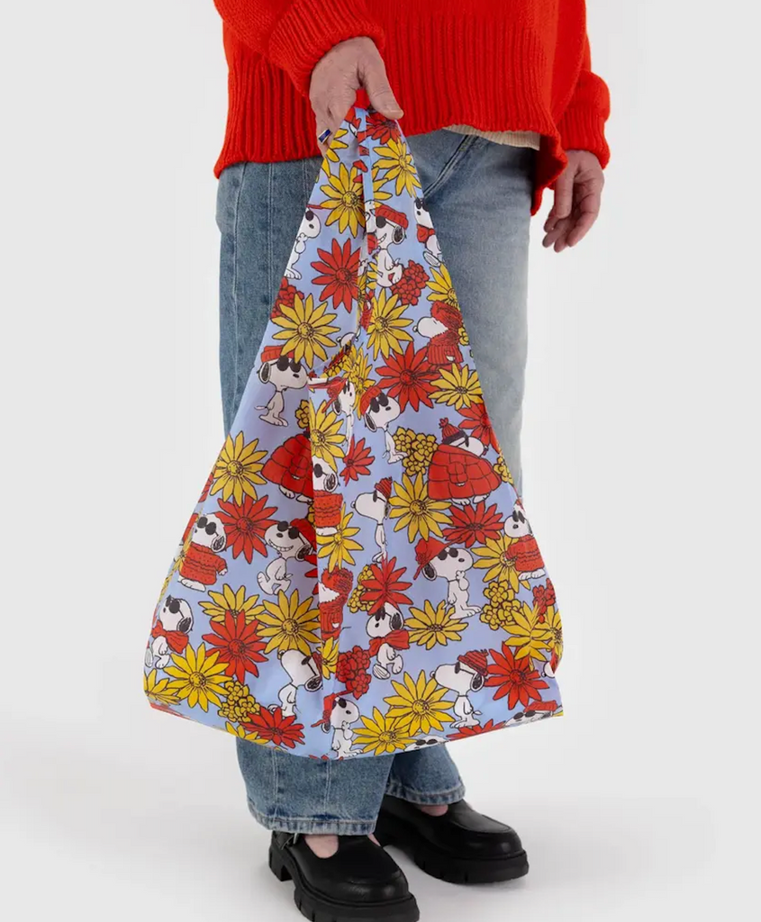 Standard size Baggu bag with the Floral Snoopy pattern printed on it, which features Snoopy wearing a big red puffy jacket, hat and sunglasses along with golden yellow and dark orange flowers. 