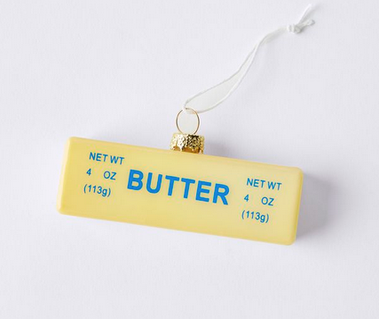 Small yellow stick of butter glass ornament. Blue Text on side reads Butter, net wt 4 oz.