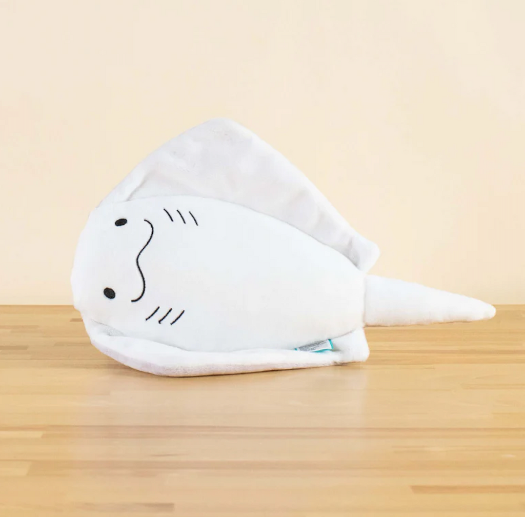 Stingi the Stingray plush toy flipped up on it's side showing the expressive face  of Stingi. 