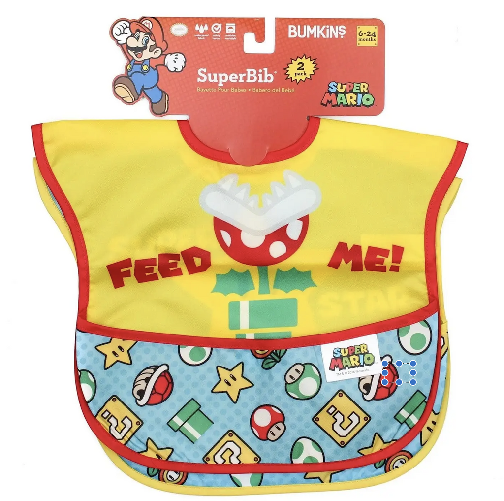 The Super Mario Super Bib 2 pack hung on a red cardboard hanger. The bright yellow bib with the Pirahna Plant on the front with red letters that read "feed Me" and the catch all pocket featuring Super Mushrooms and question blocks as well as other characters. 