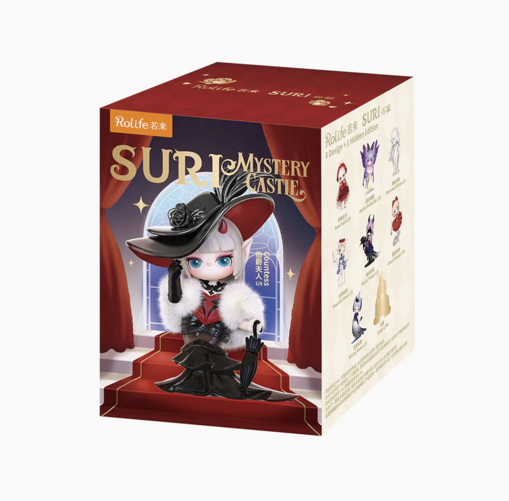Suri a dreamy elf girl collectible figure packaged in a box with a picture of Suri dressed in a black dress with burgundy accents and a hat to match. Onthe side of the box are pictures of each of the figures available in the the series. 