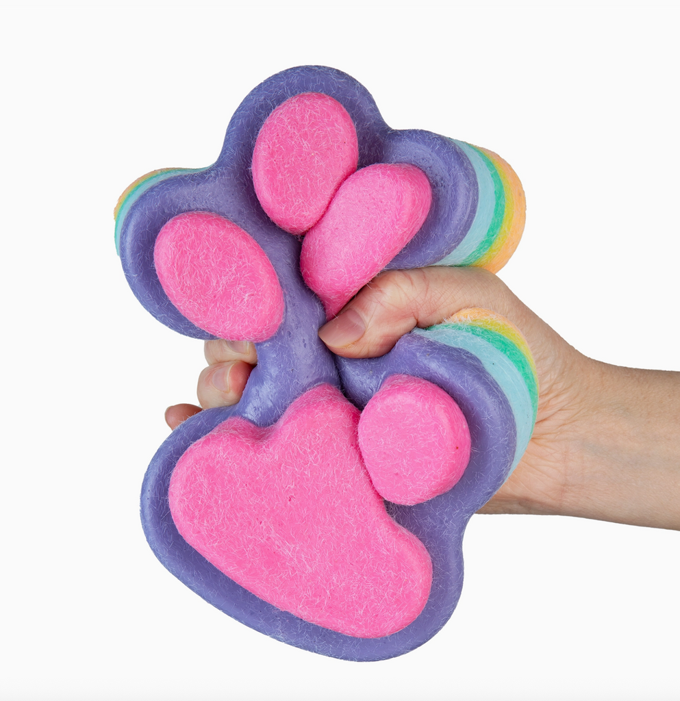 Colorful paw-shaped Taba-Licious jumbo paw being squeezed in a hand. 