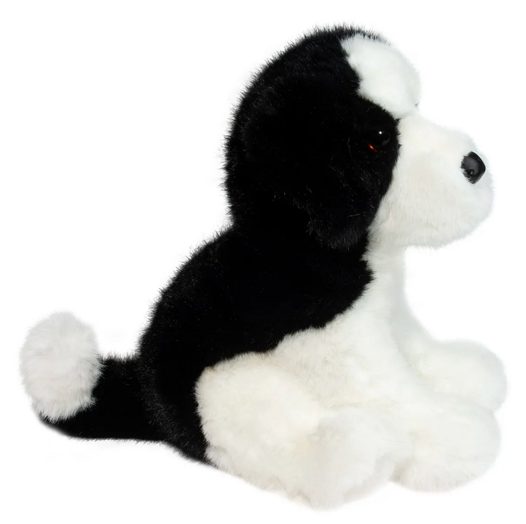 Teefer the plush Shih Tzu looking to the left with white fur in the front and black fur down his back. 