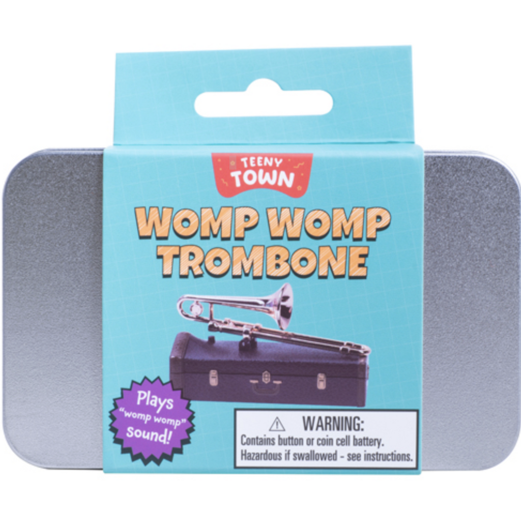Teenyb Town Womp Womp Trombone packaged in a silver tin that can be used to store the miniature trombone. The tin is wrapped in a blue label with a picture of the trombone resting on it's case. 